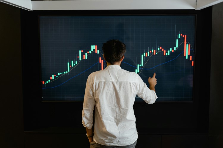 Man standing in front of trading chart